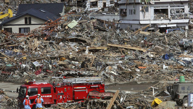 Fire fighters search for survivors following the March 11 earthquake and tsunami in Rikuzentakata, Iwate prefecture, northeastern Japan, Friday, March 18, 2011.(AP Photo/Koji Sasahara) 
