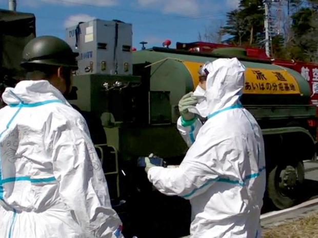 Japan Self-Defense Forces personnel talk before starting to spray water toward the Unit 3 of the troubled Fukushima Dai-ichi nuclear complex March 18, 2011. 