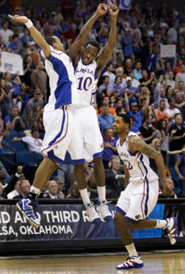 Kansas' Travis Releford, left, Tyshawn Taylor and Marcus Morris, right, celebrate 