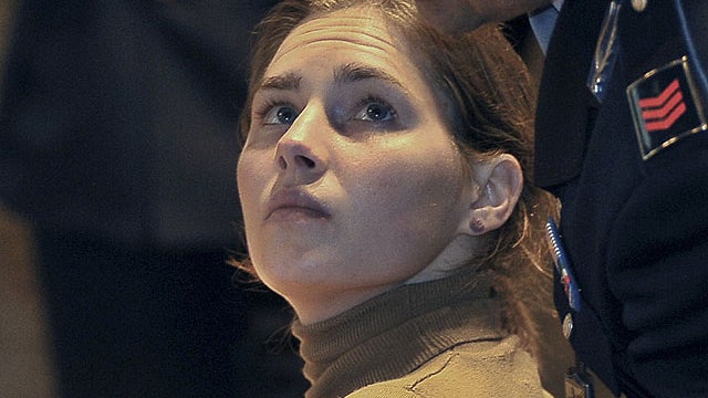 Amanda Knox looks up at a police officer as she sits in court in Perugia, central Italy, March 26, 2011, during her appeals trial. 