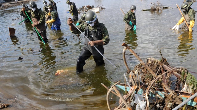 Workers search for bodies off the coast of Sendai, Japan 