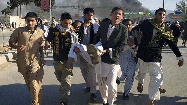 Afghans carrying a man, who got wounded following an attack on UN's office during a demonstration to condemn the burning of a copy of the Muslim holy book by a Florida pastor, in Mazar-i- Sharif north of Kabul, Afghanistan on April. 1, 2011.  