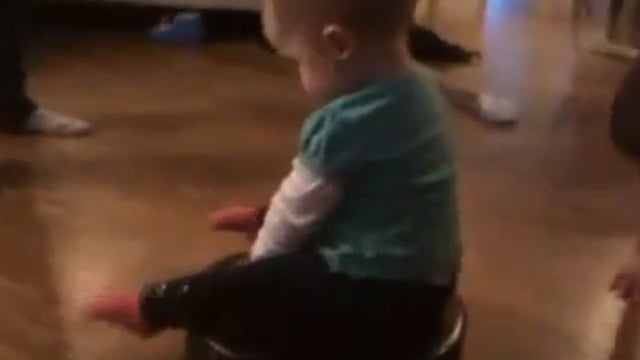 baby rides a Roomba 