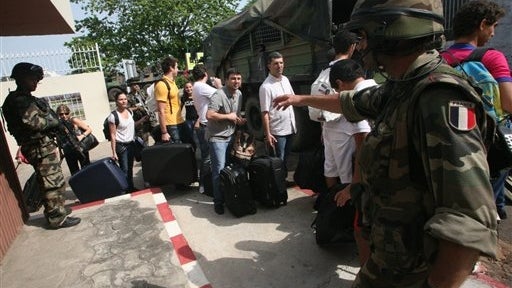 Members of the French military evacuate French nationals and other foreigners Thursday from a hotel in Abidjan , Ivory Coast.  