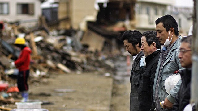 Japanese stop for a moment of silence at 2:46pm, exactly a month after a massive earthquake struck the area in the port town of Kesennuma, Miyagi Prefecture, Japan, April 11, 2011. 