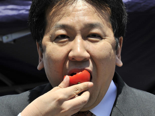 Japan's Chief Cabinet Secretary Yukio Edano eats a tomato 
