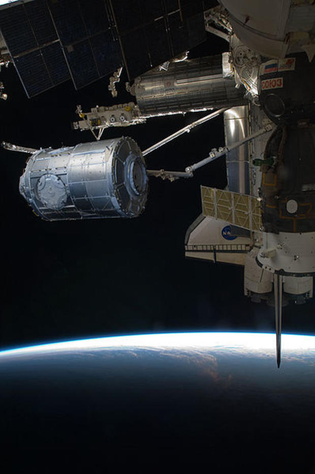 In the grasp of the International Space Station's robotic arm, Canadarm2, the Tranquility module is transferred from its location in Endeavour's  payload bay to position it on the port side of the Unity node of the International Space Station during missi 