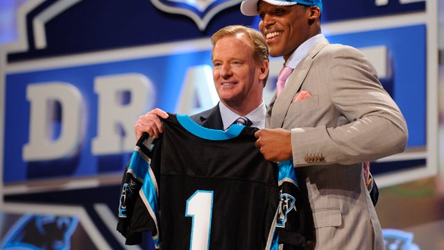 Auburn Quarterback Cam Newton holds up a jersey with NFL commissioner Roger Goodell  