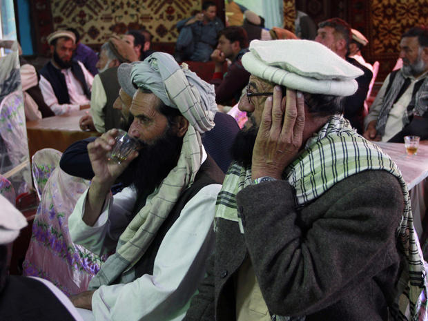Afghan men gathered to watch television coverage announcing the killing of Al-Qaida leader Osama bin Laden  