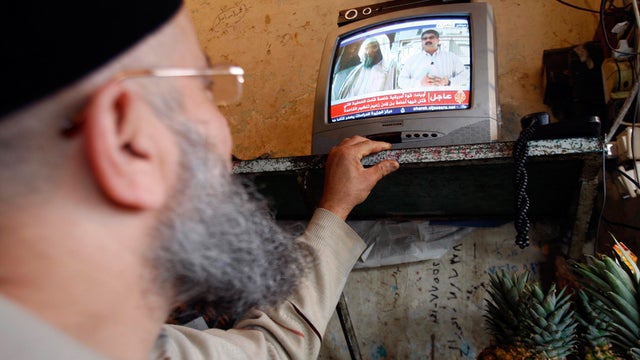  man watches a TV broadcast on the death of Osama bin Laden at a vegetable shop in the southern port city of Sidon, Lebanon 