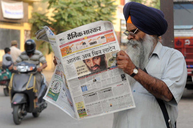 An Indian Sikh reads a newspaper display 