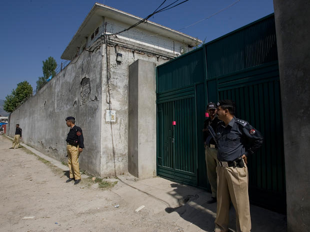 Police officers secure the perimeter, with a sealed gate into the compound and house where Osama bin Laden was caught and killed 