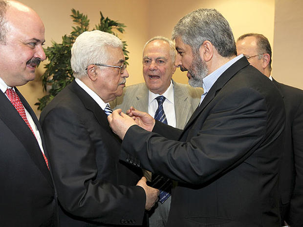 In this photo released by the Hamas Media Office, Palestinian President Mahmoud Abbas, center-left, and Hamas leader Khaled Mashaal, center-right, speak to each other at a ceremony in Cairo, Egypt Wednesday, May 4, 2011. 
