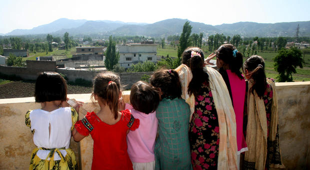 Pakistani children look out from their high vantage point, to see the compound of Osama bin Laden in Abbottabad, Pakistan 