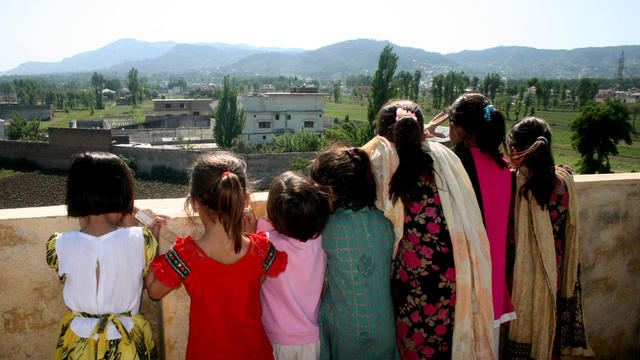 Pakistani children look out from their high vantage point, to see the compound of Osama bin Laden in Abbottabad, Pakistan 