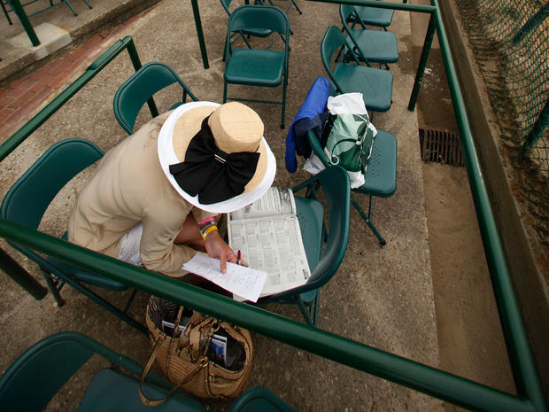 Amanda Lasater, of Mason, Tx., checks the racing program ahead of the 137th Kentucky Derby horse race at Churchill Downs Saturday, May 7, 2011, in Louisville, Ky. 
