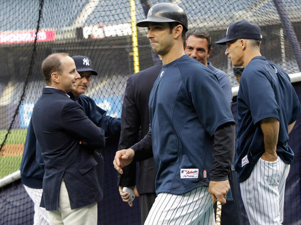 Jorge Posada walks past New York Yankees manager Brian Cashman, left, and manager Joe Girardi 
