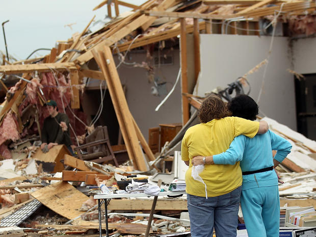 Residents hug outside a home destroyed in Joplin 