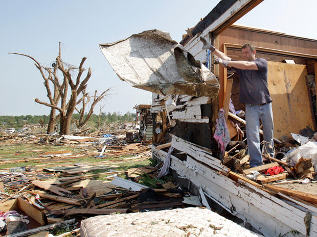 Chad Efird tosses debris out of a house 