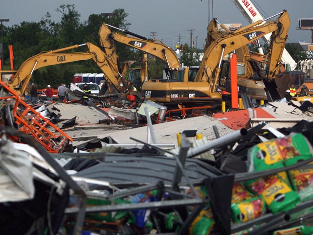 Bulldozers sift through the rubble 