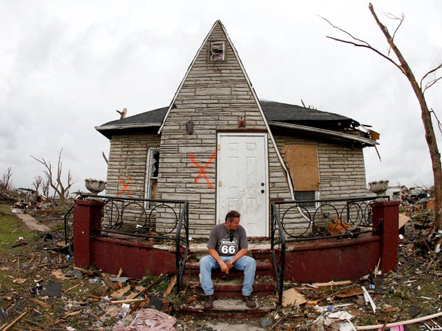 Bruce Hawkins takes a break from clean up at his moderately damaged home 