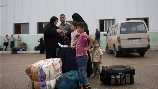 Palestinian family waits before crossing into Egypt through Rafah border crossing, southern Gaza Strip, on Saturday 