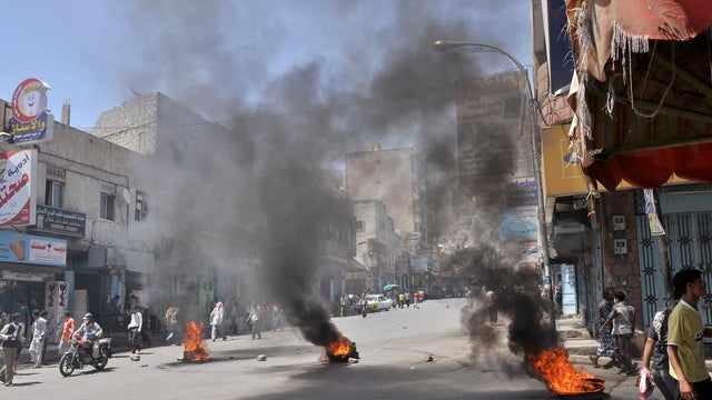 Burning tires left by anti-government protestors as they block the road during clashes with Yemeni security forces 