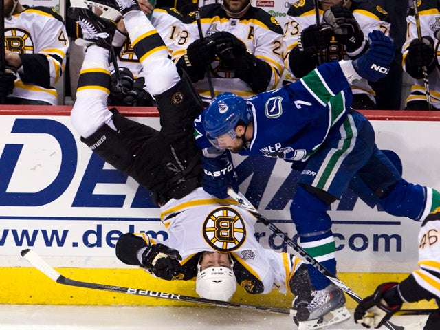 Milan Lucic is upended by Dan Hamhuis 