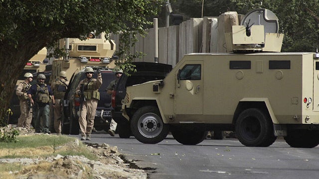 Security contractors inspect their armored vehicles after a roadside bomb attack in Baghdad, Iraq, June 6, 2011.  