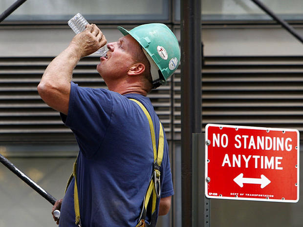 construction worker drains a bottle of water  