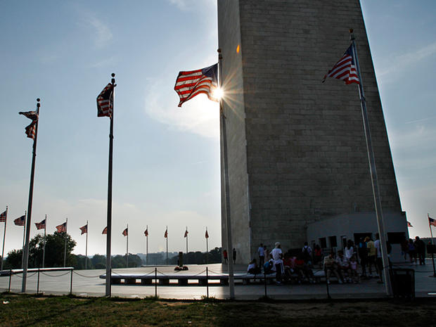 people take sheler beneath the shadow of the Washington Monument 