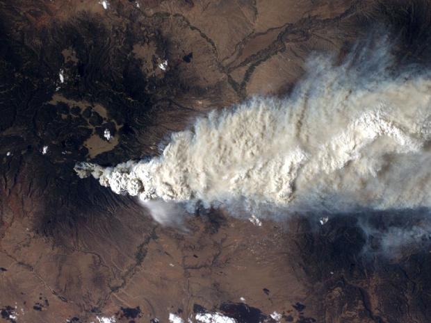 An International Space Station crew member took this photo of the Las Conchas fire near Los Alamos, N.M., on Monday, June 27, the fire's second day. The green mountains to the left (west) are the Jemez Mountains, a large volcano featuring a sunken ring-sh 