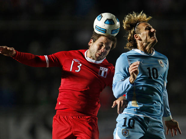 Uruguay's Diego Forlan, right, and Peru's Renzo Reveredo go for a header  