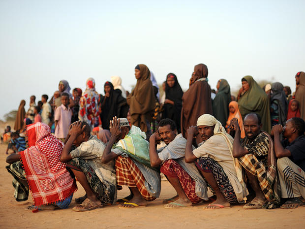 refugees line up in the early morning outside a food distribution point 