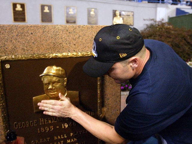 Roger Clemens center rubs the plaque of Babe Ruth 