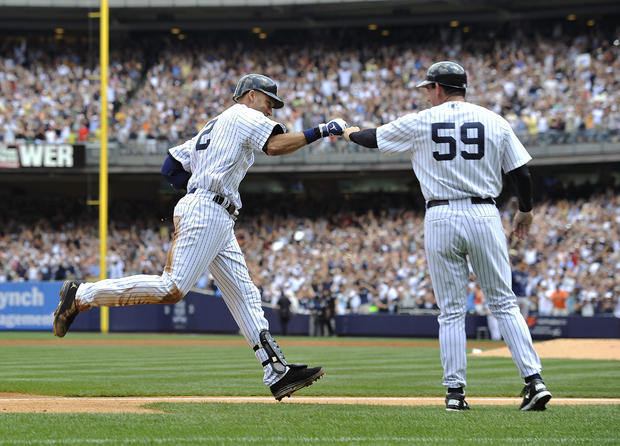 Derek Jeter is congratulated by third base coach Rob Thomson 