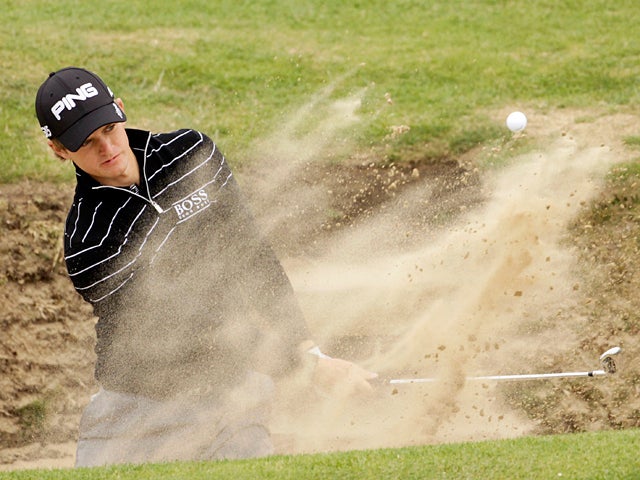 Tom Lewis hits a shot out of the bunker 