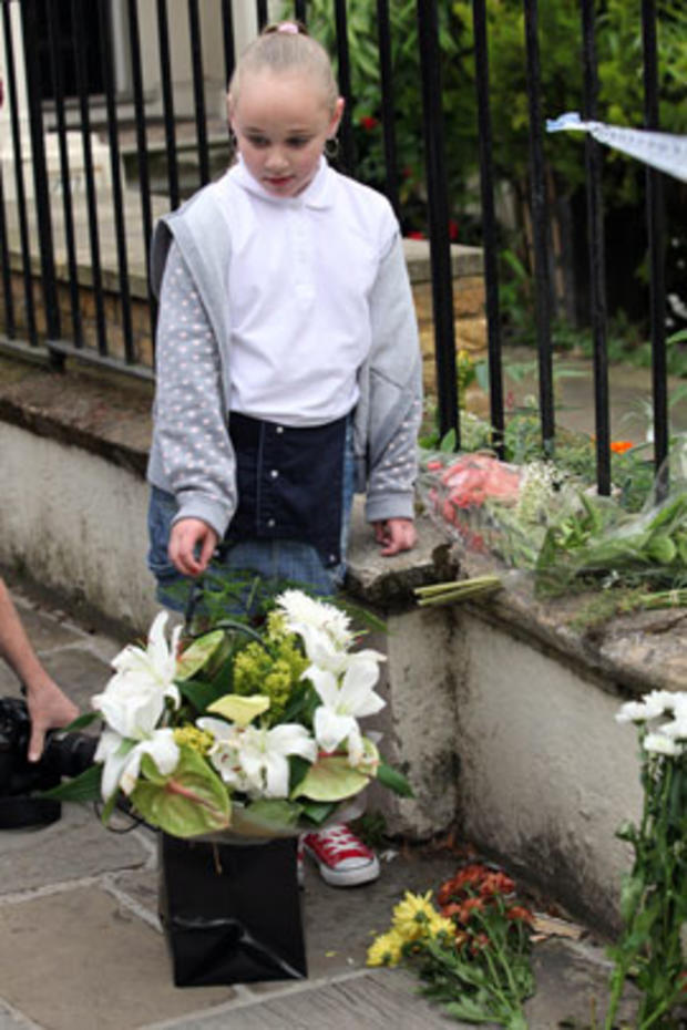 A young mourner stands with flowers outside Amy Winehouse's North London Home on July 23, 2011 in London, England. 