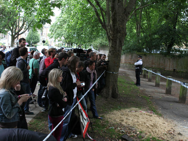 People gather behind a police cordon outside Amy Winehouse's North London Home on July 23, 2011 in London, England.  