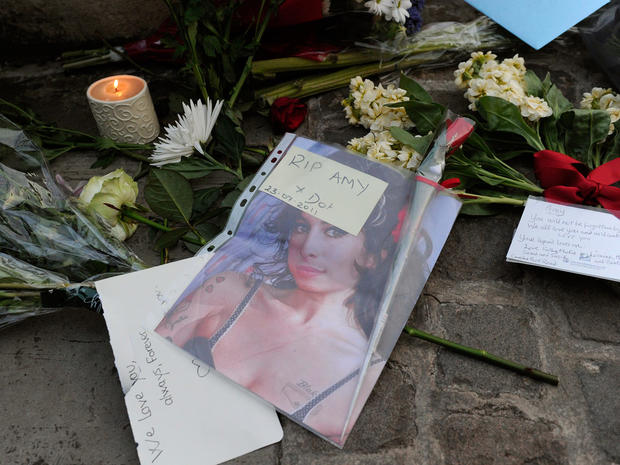 Flowers and messages are left near the house in north London where the body of  Amy Winehouse was found.  