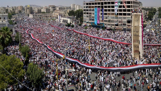 Lebanese activists carry candles during a candlelit vigil in support of the Syrian people in Beirut July 31, 2011, as they stand in front of the statue of late anti-Syrian journalist and activist Samir Kassir, who was killed by a bomb placed under his car 