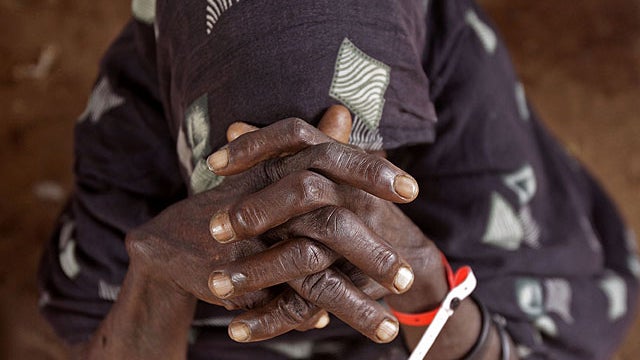 An elderly woman waits inside a food distribution center after being registered as a refugee in Dadaab, Kenya, Aug. 1, 2011.  