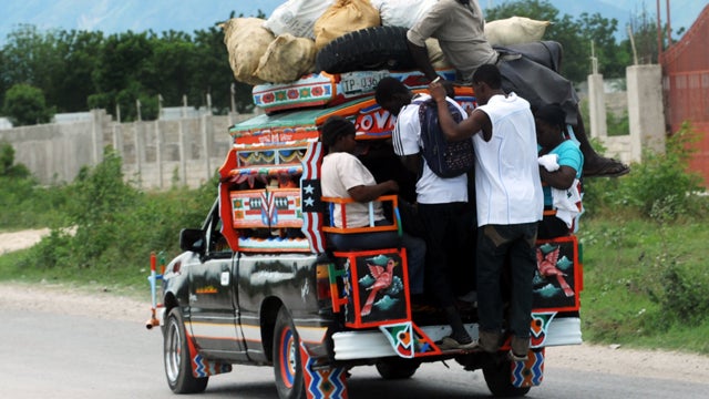 People exit with supplies Aug. 4, 2011 near Port-au-Prince, Haiti. Tropical Storm Emily whipped southern Haiti with wind and rain as hundreds of thousands huddled in squalid makeshift camps, some perched precariously on bare, slippery hillsides. After mea 