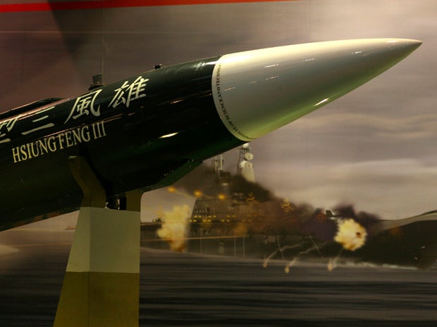 Taiwan's indigenous Hsiung Feng III missile is propped against the backdrop of a billboard depicting a missile-riddled aircraft carrier closely resembling China's carrier Varyag during a media preview of the Taipei Aerospace and Defense Technology show in Taipei, Taiwan, Aug. 10, 2011. Taiwan is hailing its most advanced missile as "an aircraft carrier killer" on the same day that China began sea trials of its first aircraft carrier, the refit Ukranian-built Varyag.
