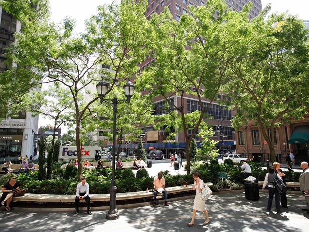 People relax under shade trees at the British Garden at Hanover Square in New York on July 15, 2011.  