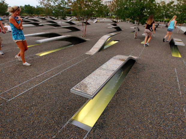 Visitors walk by benches at the Pentagon Memorial outside of the Pentagon building in Arlington Va.  