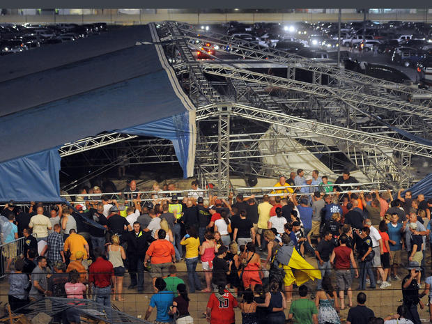 Fans waiting to see Sugarland attempt to hold up the stage after high winds blew the stage over at the Indiana State Fair Grandstands, in Indianapolis 