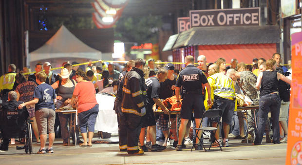 Family members tend to their injured relatives as Indianapolis Fire Department personnel and paramedics tend to the victims of a stage collapse before a concert at the Indiana State Fair Grandstands 