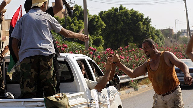 Local residents greet advancing rebel fighters on the outskirts of Tripoli, Libya, Aug. 22, 2011.  