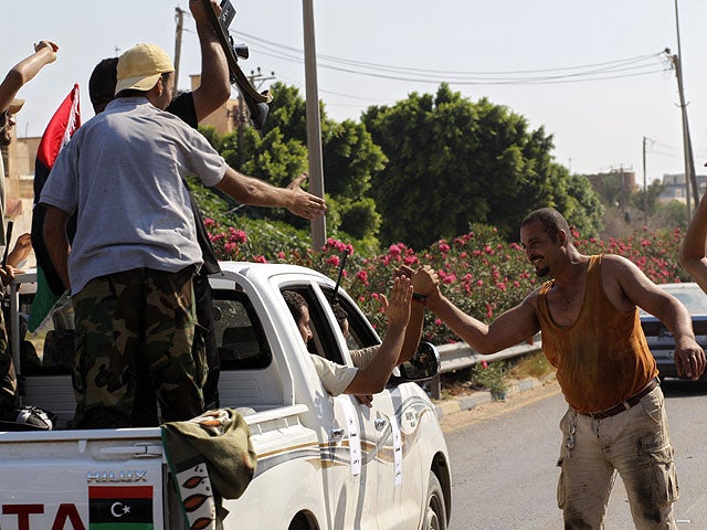 Local residents greet advancing rebel fighters on the outskirts of Tripoli, Libya, Aug. 22, 2011.  